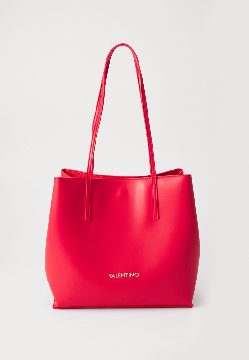 Saco tote vermelho feito de material brilhante, com duas alças longas e um design simples. Nome da marca "VALENTINO" em relevo dourado na parte inferior.