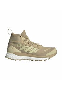 Chaussure de randonnée Adidas Terrex beige montante avec tissu GORE-TEX, semelle blanche amortie et semelle crantée texturée pour une utilisation en plein air.