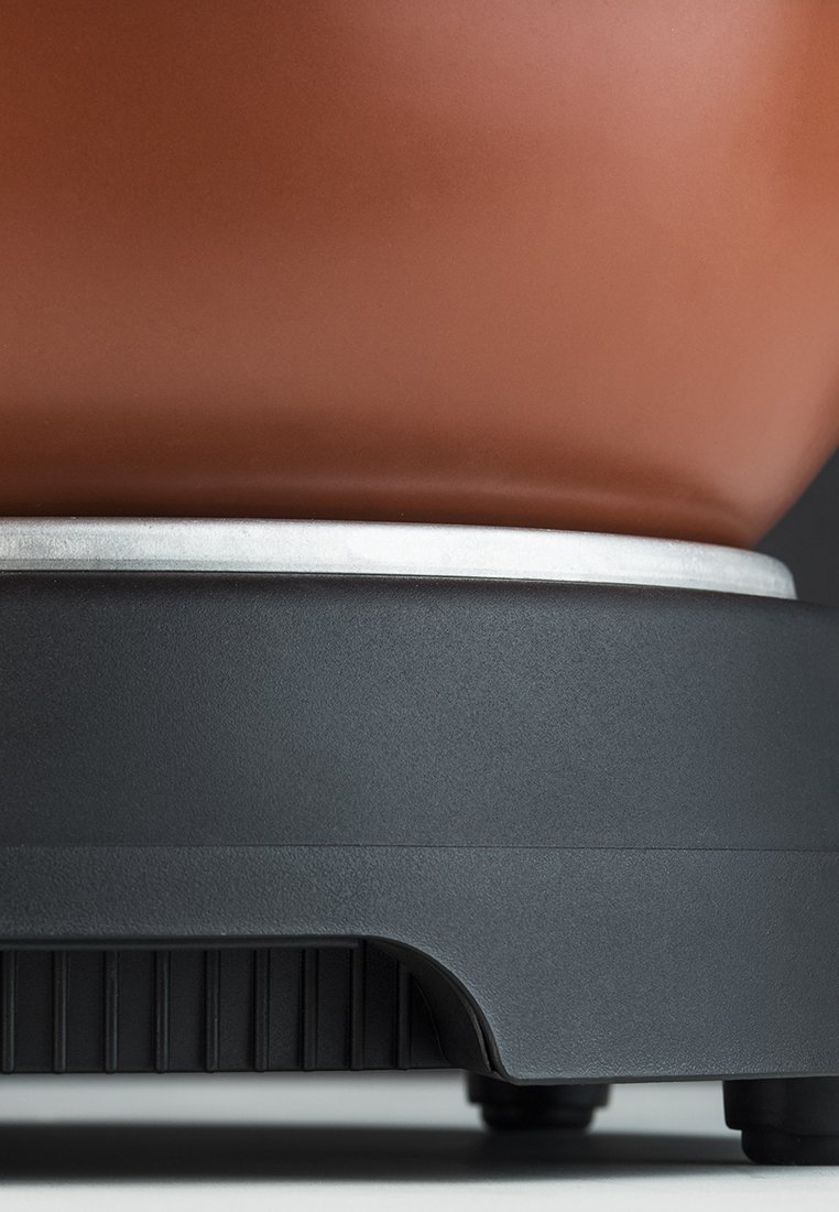 Braune Keramikschüssel mit glatter Oberfläche steht auf einem matt schwarzen Kunststoffsockel, der ein silbernes Band und strukturierte Akzente für besseren Halt aufweist.