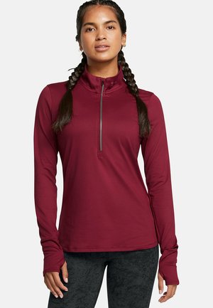 Camiseta deportiva roja de manga larga con cuello con cremallera, que presenta orificios para los pulgares y un diseño ajustado. Textura de tela suave y detalles de costura mínimos.