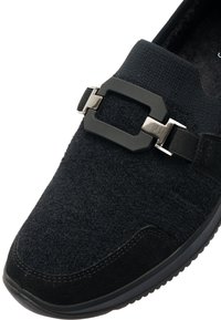 Schwarze Sneakers mit einem strukturierten Obermaterial aus Stoff und Wildleder, akzentuiert durch eine rechteckige Schnalle und einer Gummisohle.