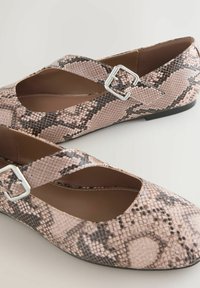 Snake-print flats in soft pink and black, featuring a crisscross strap with a metallic buckle, smooth inner lining, and low-profile sole.