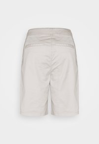 Shorts beige clair en coton, présentant une coupe décontractée, deux poches arrière et une texture lisse avec des détails de coutures simples.