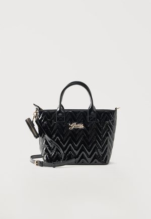 Sac à main noir brillant matelassé avec anses supérieures, bandoulière amovible, petite pochette zippée et logo doré "Guess" sur le devant.