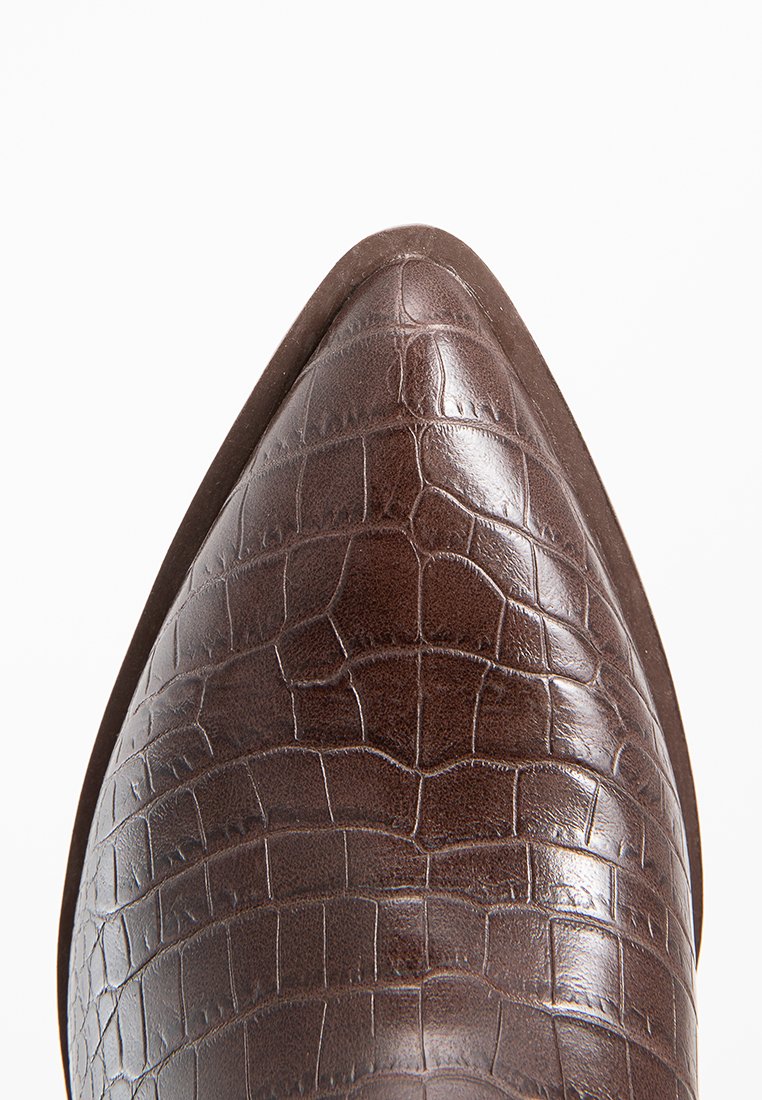 Scarpa in pelle marrone a punta con texture a motivo coccodrillo. Finitura liscia con un design elegante e tacco leggermente rialzato.