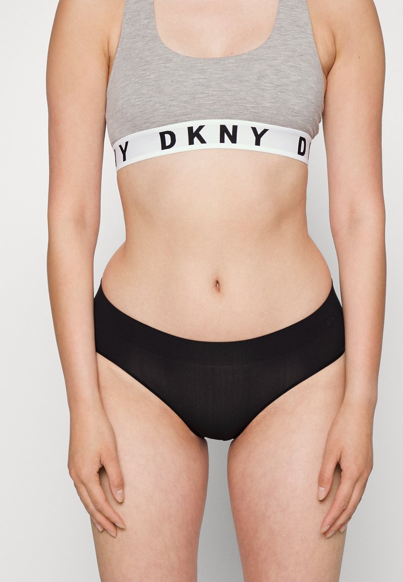 Čierne bikiny s hladkým, elastickým pásom. Šedý crop top so spodným bielym pásom s čiernym písmom.