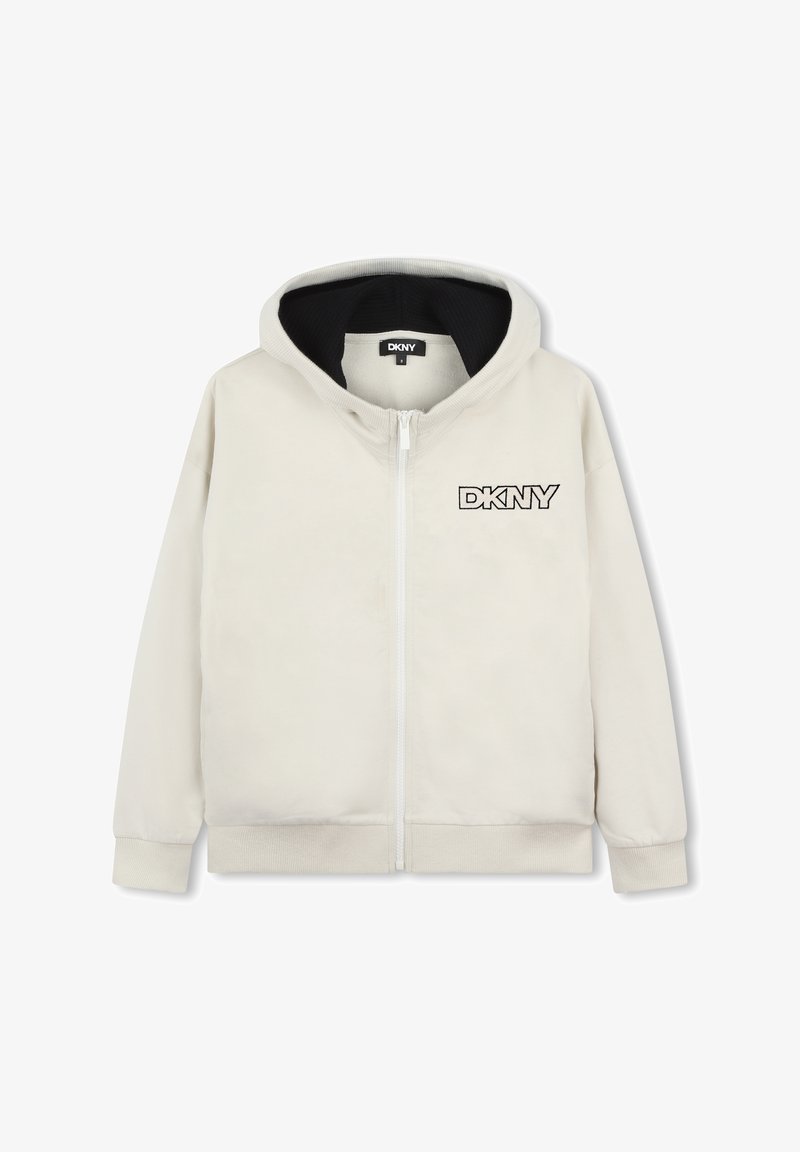 Haut à capuche zippé beige clair en tissu doux. Présente une doublure intérieure noire et un logo DKNY brodé sur la poitrine gauche. Manches longues.