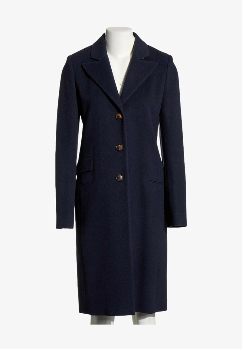 Long manteau en laine bleu marine avec trois boutons marron, deux poches avant et un col cranté sur un mannequin.