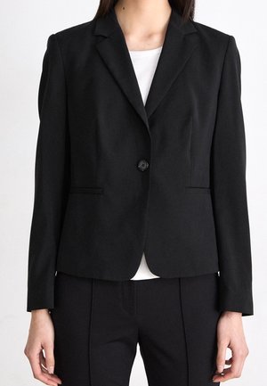 Black blazer with a single button closure, notched lapels, and subtle side pockets. Made of smooth fabric, features a tailored fit.