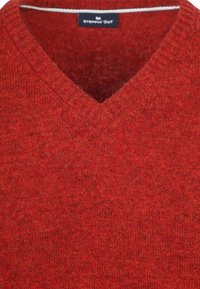 Roter V-Ausschnitt-Strickpullover mit geripptem Kragen und "Steppin' Out"-Markenlabel im Nacken.