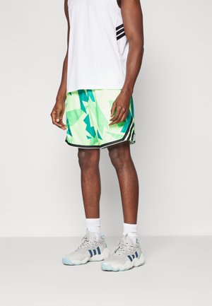 Man draagt een wit mouwloos shirt, groene shorts met een geometrisch patroon, witte sokken en grijze sportschoenen met blauwe strepen.