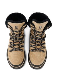 Beige semišové boty s černou kožešinovou podšívkou, černo-bílými tkaničkami, vyztuženými očky a kulatou špičkou. Černé gumové podrážky pro lepší trakci.