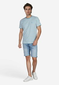 Gestreiftes T-Shirt in helltürkis und Weiß, runder Ausschnitt, getragen mit hellen Jeansshorts und weißen Sneakers.