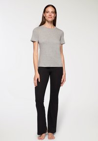 Szary t-shirt z krótkim rękawem i okrągłym dekoltem, w połączeniu z czarnymi spódnicami rurkami, wykonanymi z gładkiego materiału, dopasowanym krojem i długości do kostek.
