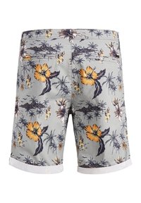 Světle šedé kraťasy s tropickým vzorem, na kterém jsou žluté květy hibisku a palmy. Tkanina vypadá hladce, lem je s vítaným rolovaným zakončením.