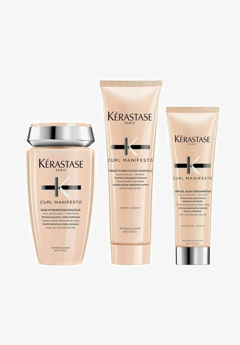 Drei Kérastase Curl Manifesto Haarprodukte: ein cremiges Shampoo, ein leichtes Shampoo und eine Leave-In-Behandlung, alle in sanften rosa Tuben.