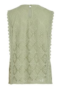 Haut sans manches vert clair en dentelle avec des motifs découpés en losanges et fleurs, bordure festonnée sur les côtés, et petite fermeture à bouton en trou de serrure à l'arrière du col.