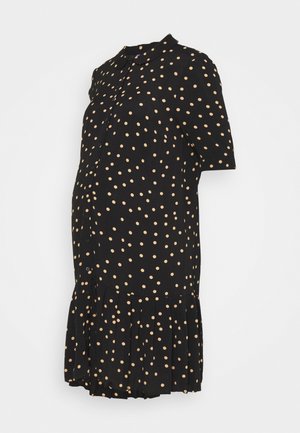 Schwarzes Umstandskleid mit kurzen Ärmeln und beigen Polka Dots, vorne mit Knöpfen, einem Kragen und einem plissierten Saum.