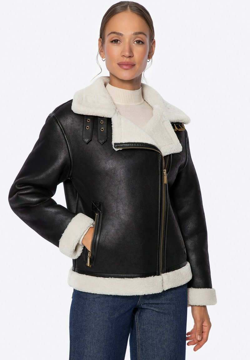 Czarna skórzana kurtka z białym sztucznym kołnierzem i mankietami z owczej wełny, z złotymi detalami, zapięciem na zamek oraz dwoma bocznymi kieszeniami.