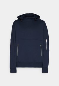 Felpa blu navy realizzata in tessuto morbido, con collo alto, coulisse regolabili e due tasche laterali con zip.