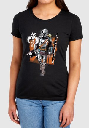 Mandalorian in armor walking with Grogu on shoulder, white Mandalorian skull symbol, and text "Mandalorian & Grogu" on black shirt.