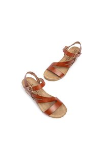 Sandali in pelle marrone con cinturini incrociati, fibbie regolabili e suola imbottita. Suola piatta con fondo texturizzato.