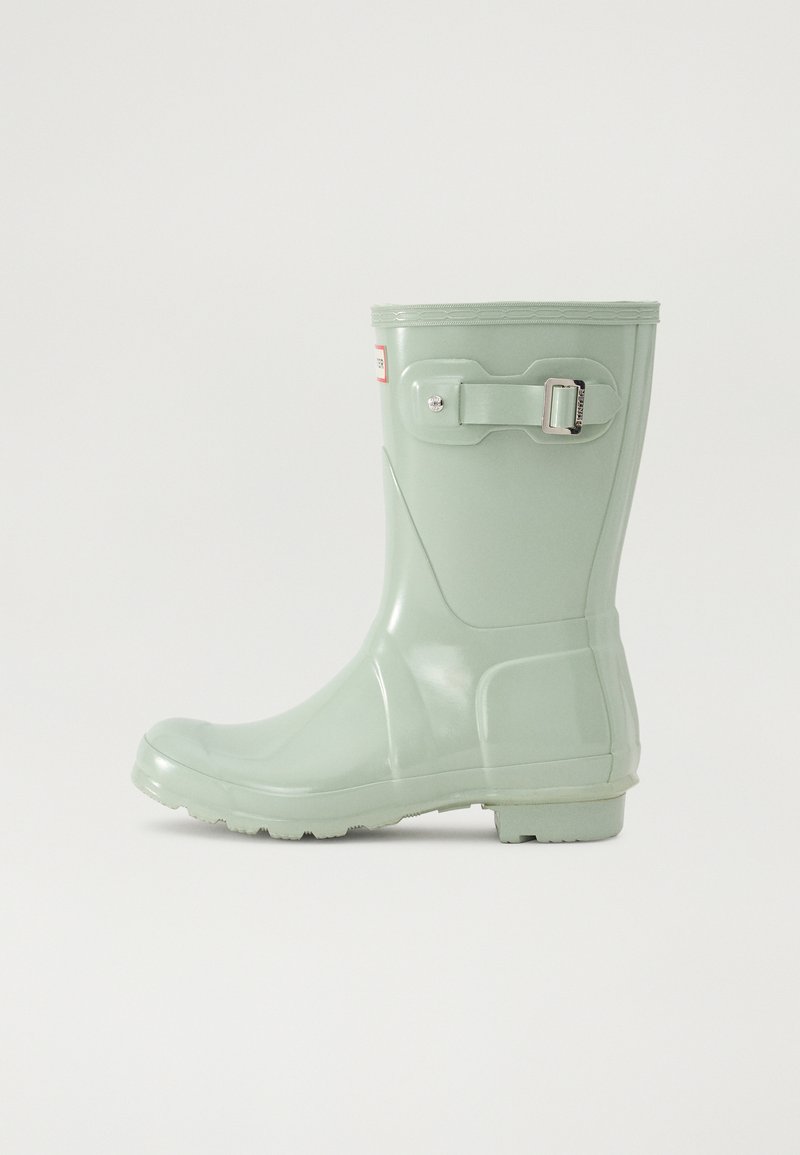 Bottes de pluie en caoutchouc vert à finition brillante, avec un détail de boucle, une semelle texturée et un design à bout rond.