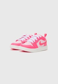 Różowe sneakersy wykonane z materiału syntetycznego, z białymi sznurówkami, perforowanym noskiem i kontrastowym logo. Okrągła gumowa podeszwa zapewniająca przyczepność.