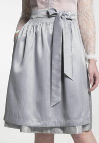 Jupe en satin gris avec une texture lisse, taille froncée et nœud noué à l'avant. Présente une doublure à motif floral qui dépasse au niveau de l'ourlet.