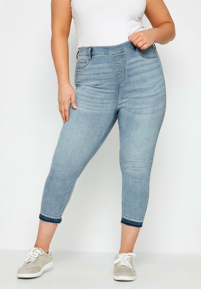 Jeans Capri in denim azzurro chiaro con vita alta, dotati di tasche anteriori e posteriori, leggera scoloritura e dettagli con orlo sfilacciato.