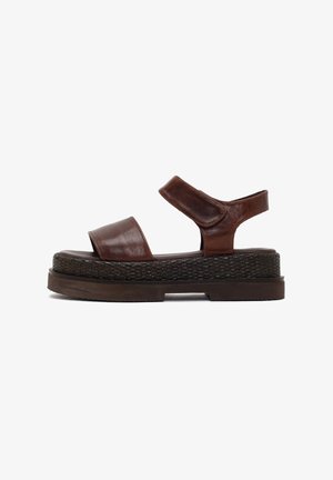 Brown leather platform sandal with two straps and thick woven-texture sole, viewed from the side on a white background.