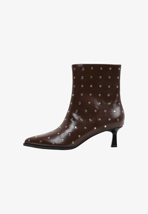 Bottine en cuir marron avec petit talon noire bas de type kitten heel et petits clous argentés répartis uniformément sur toute la surface.