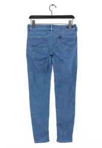 Modré džínové skinny džíny zavěšené na černém ramínku, zobrazené zezadu se dvěma zadními kapsami a poutky na pásek.