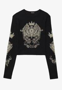 Black long-sleeve cropped top with ribbed texture. Features intricate cream-colored graphic design with crowns and flowers on the front and sleeves.