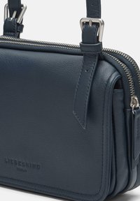 Borsa a mano in pelle blu con finitura texture, chiusura superiore con zip e tracolla regolabile. Presenta il logo del marchio impresso sul davanti.