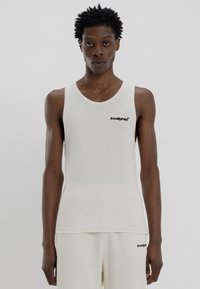 White ribbed tank top featuring a round neckline and black logo on the chest. Made from a smooth, lightweight fabric with a fitted shape.