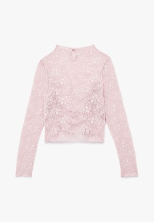 Top a maniche lunghe, corto, in pizzo rosa trasparente con motivi floreali. Presenta un collo alto e una chiusura a bottoni sul retro.