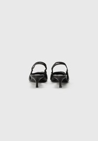 Pantofi eleganți cu toc înalt de culoare neagră, cu un design sofisticat, spate deschis și curea subțire la gleznă. Au o textură de piele lucioasă și un toc conic.