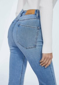 Lichtblauwe denim jeans met een hoge taille, voorzien van twee achterzakken, subtiele stiksels en een tan leren label op de tailleband.