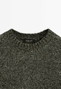 Dark grey knit sweater with a ribbed crew neckline and textured pattern. Label reads "Massimo Dutti." Soft, medium-weight fabric.