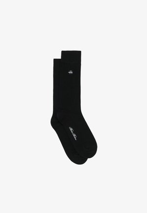 Chaussettes en coton noires à texture lisse, avec un petit logo d'ours blanc et le nom de la marque blanc brodé sur le côté.