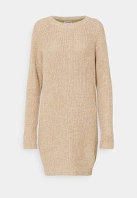 Robe pull en tricot beige clair avec une coupe ample, des manches longues raglan, des poignets côtelés et un motif texturé sur toute la surface.