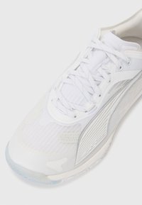 Witte sportieve sneaker van mesh en synthetisch materiaal, met een gladde textuur, vetersluiting en een transparante rubberen zool. Zilveren accenten aan de zijkant.