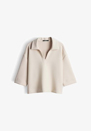 Beige, kort mouwen top met kraag en V-hals. Gemaakt van gladde stof, met een ontspannen pasvorm en licht verlaagde schoudernaden.