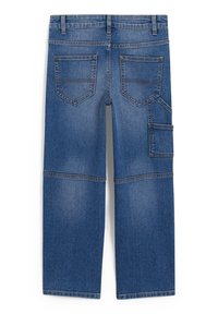 Vue arrière d'un jean en denim bleu avec deux poches arrière et une poche utilitaire latérale supplémentaire sur la jambe droite.