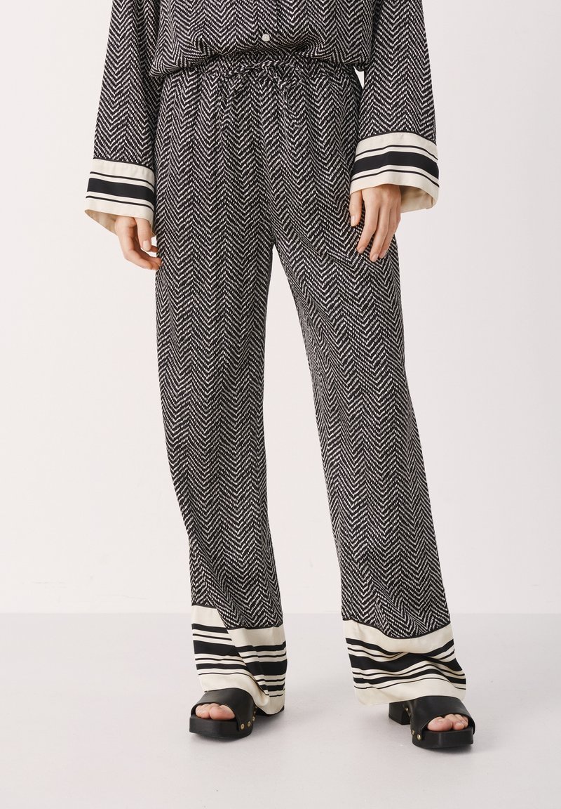 Zwart-witte visgraat pyjamabroek met een trekkoord in de taille en gestreepte boorden, met een ontspannen pasvorm en een zachte stof.