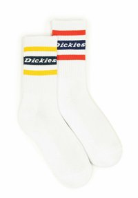 White crew socks with ribbed texture featuring navy, yellow, and red stripes on the cuffs. "Dickies" logo displayed on each sock.