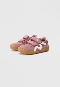 Różowe sportowe buty zamszowe z białymi akcentami, paskami na rzepy oraz elastyczną gumową podeszwą o fakturowanym wzorze.