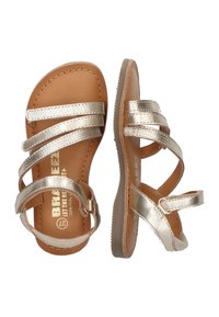 Gouden metallic sandalen met drie brede bandjes, verstelbare gesp en bruine leren binnenzool. Platte rubberen zool met een lichte textuur.