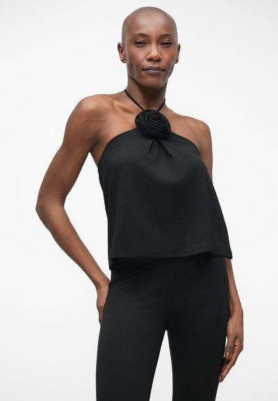 Černý halter top s uzlovým detailem ve tvaru růže na výstřihu, vyrobený z jemného materiálu, s volným a splývavým designem.